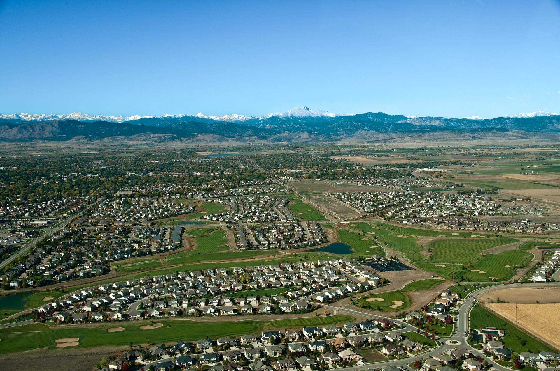 A large expanse of plains with mountains in the background, residential neighborhoods in the foregorund